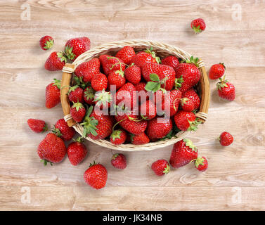 Frische Erdbeeren im Korb auf hölzernen Hintergrund. Ansicht von oben. Hohe Auflösung. Ernte-Konzept Stockfoto