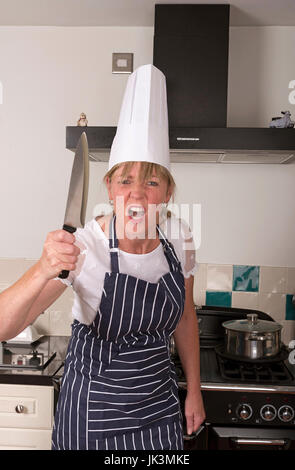 Porträt eines sehr wütend Chefs mit einem scharfen Küchenmesser in eine bedrohliche Weise Stockfoto