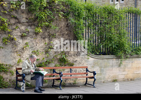 ältere Herren sitzen auf einer Holzbank-Lesung Stockfoto