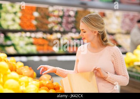 Schwangere Frau mit Tasche Orangen in Lebensmittelgeschäften zu kaufen Stockfoto