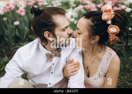 Nahen Osten paar umarmt in der Nähe von Blumen Stockfoto