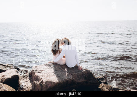 Nahen Osten paar sitzt auf den Felsen in der Nähe von Meer Stockfoto