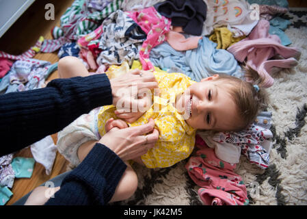 Hände der kaukasischen Mutter kitzeln Tochter Erdgeschoss Stockfoto
