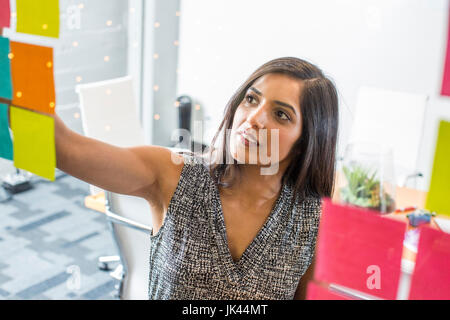 Indische Frau Kleber Notenlesen im Büro Stockfoto