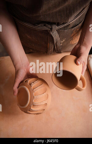 Hand des kaukasischen Frau hält Keramik Tasse und Schale Stockfoto