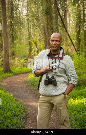 Afrikanische amerikanische Mann auf Pfad im Wald, die Kamera zu halten Stockfoto