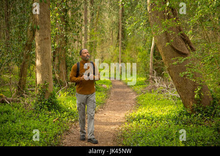 Afrikanische amerikanische Mann zu Fuß auf Weg im Wald mit Fernglas Stockfoto