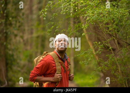 Afrikanische amerikanische Mann im Wald mit Rucksack Stockfoto