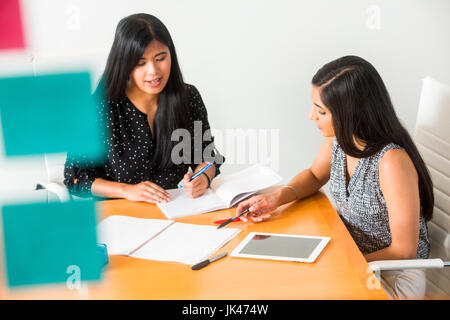 Frauen lesen Notizbücher in treffen Stockfoto