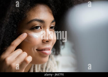 Afroamerikanische Frau, Gesicht eincremen Stockfoto