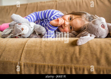 Kaukasische Mädchen Verlegung auf Sofa Daumenlutschen Stockfoto