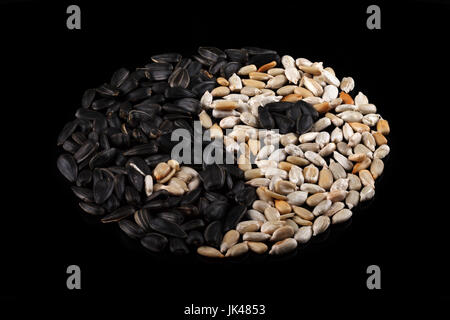 Sonnenblumenkerne auf einem schwarzen Hintergrund in Form von Yin und Yang. Ansicht von oben. Close-up Stockfoto