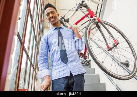 Schwarze Geschäftsmann absteigend Treppe mit Fahrrad Stockfoto