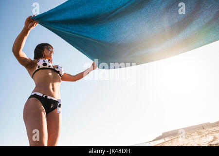Kaukasische Frau Verbreitung Decke am Strand Stockfoto
