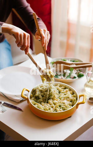 Frau, Portion Nudeln mit Holzlöffel Stockfoto