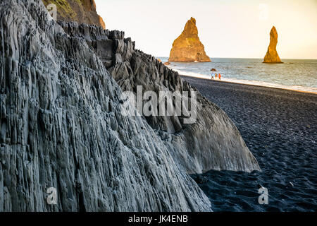 Steinerne Basaltsäulen am schwarzen Reynisfjara Strand in der Nähe von Vik Stadt, Island bei Sonnenuntergang Stockfoto