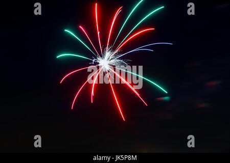 Funkelndes rot grün gelb Feier Feuerwerk über Sternenhimmel. Independence Day, 4. Juli, Silvester Urlaub Gruß Hintergrund. Stockfoto