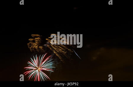 Funkelndes rot grün gelb Feier Feuerwerk über Sternenhimmel. Independence Day, 4. Juli, Silvester Urlaub Gruß Hintergrund. Stockfoto