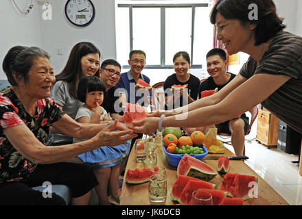 LinAn, der chinesischen Provinz Zhejiang. 22. Juli 2017. Nighty-ein-Jahr-alte touristische Jiang Hao (1. L) erhält ein Stück Wassermelone in Baisha Dorf von Lin'an, Ost-China Zhejiang Provinz, 22. Juli 2017. Mit einer durchschnittlichen Temperatur von 26 Grad Celsius im Sommer ist das Dorf Baisha in Lin'an ein beliebtes Touristenziel in der Provinz geworden. In den letzten Jahren entwickelte Tourismus auf dem Lande dramatisch in Baisha, die 90 Prozent der lokalen Arbeitskräfte beteiligt. Bildnachweis: Tan Jin/Xinhua/Alamy Live-Nachrichten Stockfoto