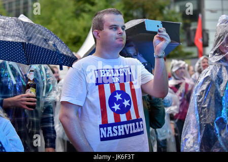 London, UK.  22. Juli 2017. Ein Fan genießt die Aufführung auf der Bühne.  "Nashville trifft London", ein Country-Musik-Festival findet statt in Canary Wharf.  Starkregen nicht den Genuss von engagierten Country-Musik-Fans, viele tragen schützende Ponchos, gerade Künstler aus Großbritannien sowie den USA für die zweitägige Festwochenende zu dämpfen.  Bildnachweis: Stephen Chung / Alamy Live News Stockfoto