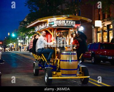 Hohe fünf Pedal Touren mit Passagieren Radfahren durch die Straßen der Innenstadt von Ann Arbor, Michigan auf einen späten Frühling Abend. Trinken, Geselligkeit. Stockfoto