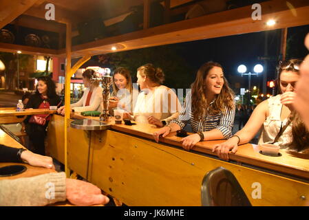 Hohe fünf Pedal Touren mit Passagieren Radfahren durch die Straßen der Innenstadt von Ann Arbor, Michigan auf einen späten Frühling Abend. Trinken, Geselligkeit. Stockfoto