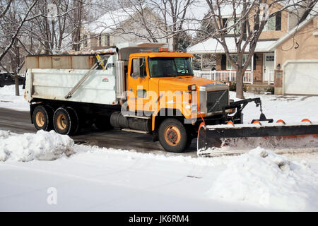 Eine orange Schneepflug Schnee vor einer Einfahrt wegzuräumen. Stockfoto