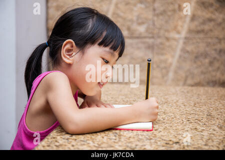 Asiatische chinesische Mädchen schreiben Hausaufgaben zu Hause Stockfoto