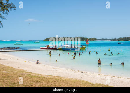 Blue Bay, Mauritius - 27. Dezember 2015: Unbekannte Menschen am Strand und Pier in Blue Bay, einem der schönsten Strände auf Mauritius und die sitzen Stockfoto