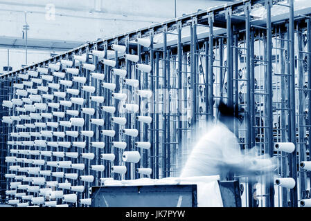 große Gruppe von Spule Gewinde Kegel auf eine Schärmaschine in einer Textilfabrik. Stockfoto