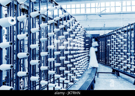 große Gruppe von Spule Gewinde Kegel auf eine Schärmaschine in einer Textilfabrik. Stockfoto