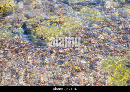 Steinen im welligen Wasser, roten Meeresstrand Stockfoto