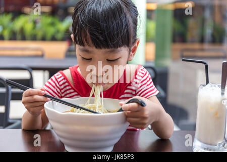 Asiatische chinesische Mädchen essen Nudelsuppe im Café im freien Stockfoto