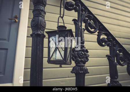 Nahaufnahme einer Laterne hängen von stilisierten Handlauf außerhalb aus Holz bauen Stockfoto