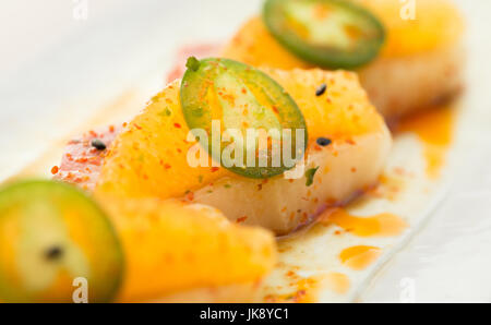 Nahaufnahme von Spezialität high-End Gelbflossen Thunfisch Sushi-Rolle mit Jalapeno auf Platte fertig zum Verzehr. Stockfoto