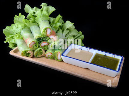 Vietnamesischer Salat roll gemischtes Gemüse und Meeresfrüchte Rollen mit Reispapier setzen auf Holzteller mit Soße. Stockfoto