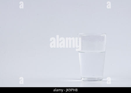 Wasser gießen in klarem Glas auf weißem Hintergrund Stockfoto