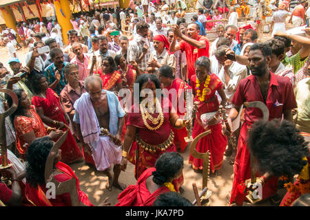 Anhänger im roten Kleid und Sickleshaped Schwerter am Sree Kurumba Sree Kurumba Bhagwati Tempel Kodungallur, während Bharani Festival, Thrissur, Kerala, Indien Stockfoto