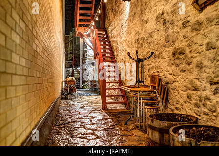 Enge Gasse mit Kopfsteinpflaster und eigenem Eingang mit Treppe zum Stein Wohnung in der Nacht Stockfoto