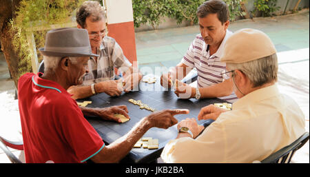 Rentner, Senioren und Freizeit. Alten Latino Männer Spaß haben und spielen Domino in Kuba. Stockfoto