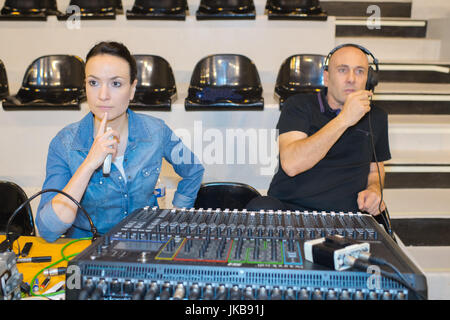 Ingenieure arbeiten am Mischpult während der Theateraufführung Stockfoto