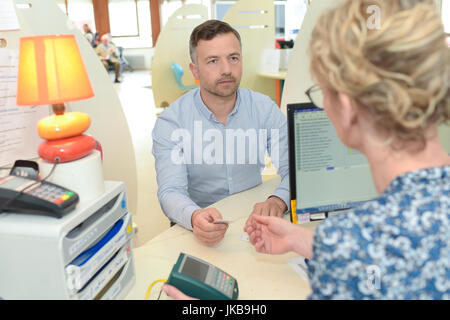 männlicher Patient Krankenhaus Rezeption registrieren Stockfoto