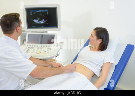 Schwangere Frau, die Ultraschallbehandlung im Krankenhaus Stockfoto