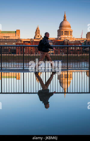 England, London, Southbank, Person spiegelt sich in der Pfütze, in der Nähe von The Millenium Bridge, Morgendämmerung Stockfoto