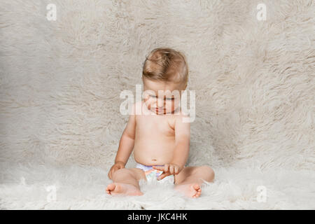 Baby Junge in Windeln, sitzen auf eine zottige hausgemachte Wolldecke Stockfoto