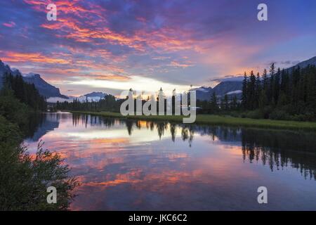 Leuchtende Sonnenuntergangsfarben Great Sky Creek Valley Landschaft. Die Canadian Rocky Mountain Peaks spiegeln sich im Calm Water Canmore Alberta Foothills Stockfoto