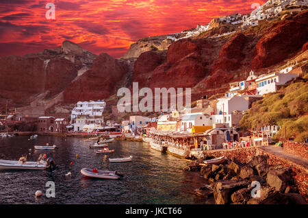 Ammoudi, Santorin, Griechenland. Amoudi Bay befindet sich unter Dorf Oia. Boote und Tavernen in der Nähe des Wassers. Stockfoto