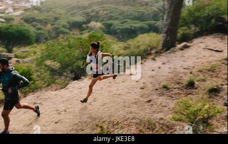 Zwei Läufer auf Bergweg. Junger Mann und Frau laufen in der Natur. Trail-running-Training. Stockfoto