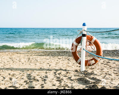 Rettungsring auf einem sandigen Strand in Terracina, Italien. Sicheres Schwimmen im Meer und Ozean. Hintergrund für eine Meeres-Themenpark oder Sicherheit im Urlaub Stockfoto