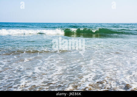 Meer Flutwellen mit weißer Schaum auf einem sonnigen Sandstrand im Resort in den Sommerferien. Hintergrund der Ozean Wasser Textur Stockfoto